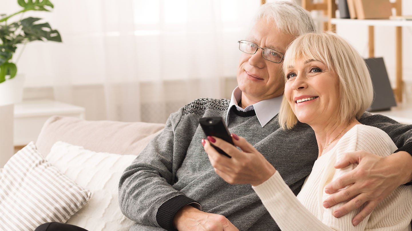 Older couple watching home movies transferred to DVD