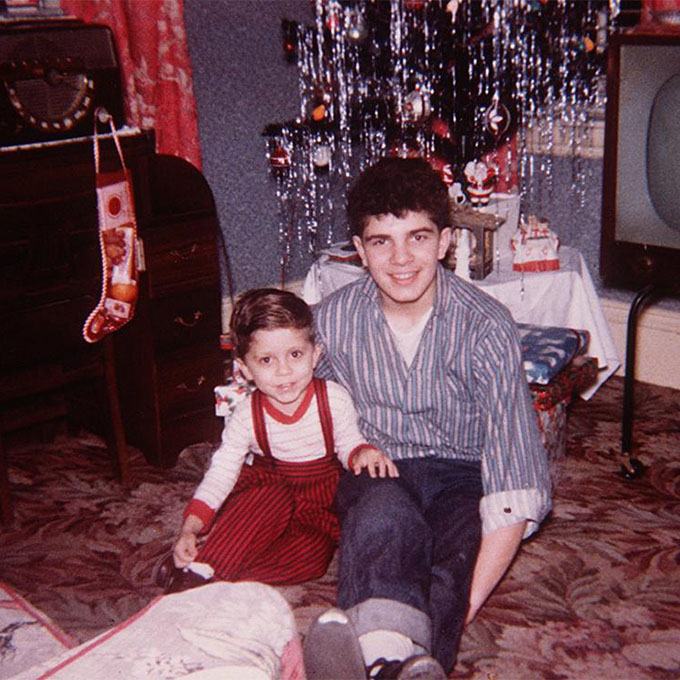 Vintage photo of father and son sitting in front of a Christmas tree